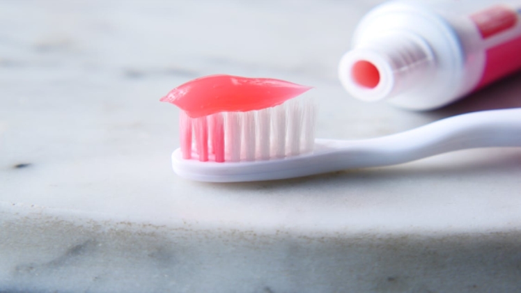 a toothbrush with toothpaste on a white surface